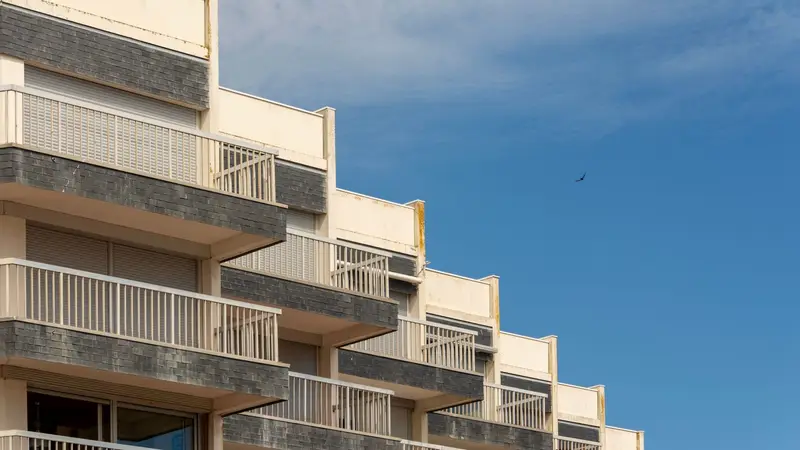 Edificio de apartamentos con balcones bajo el cielo azul