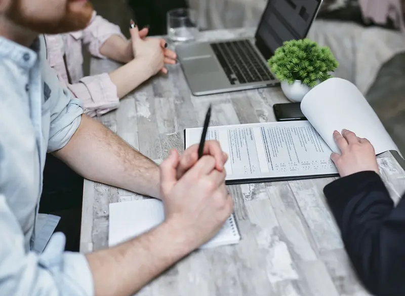 Reunión con documentos y un portátil sobre la mesa