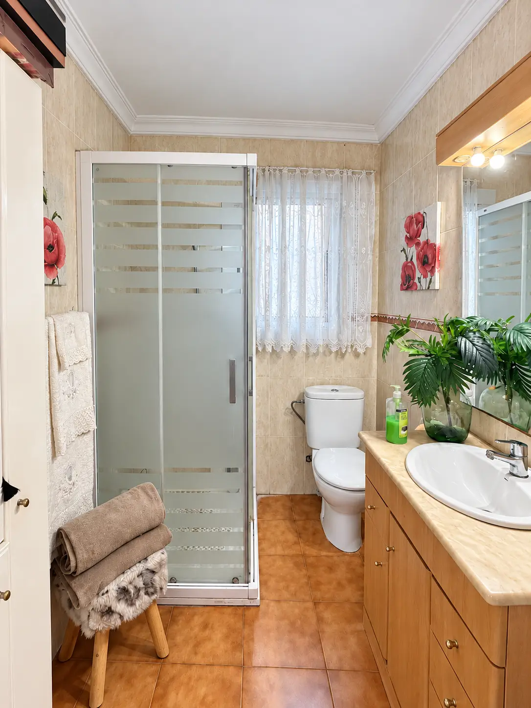 Baño con plato de ducha, lavabo con mueble e inodoro