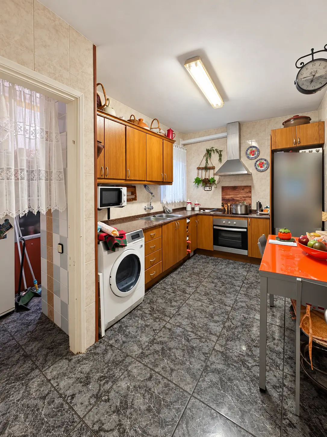 Cocina independiente con muebles de madera, horno y lavadora