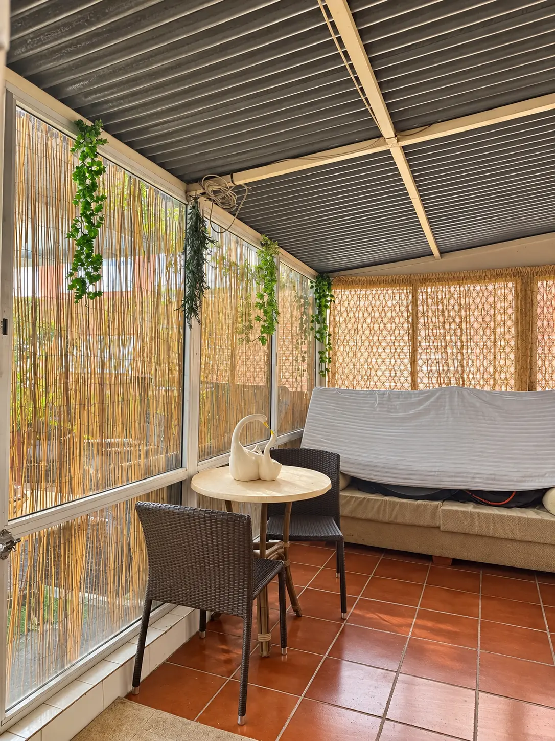 Porche cerrado de la terraza con mesa, sillas y sofá